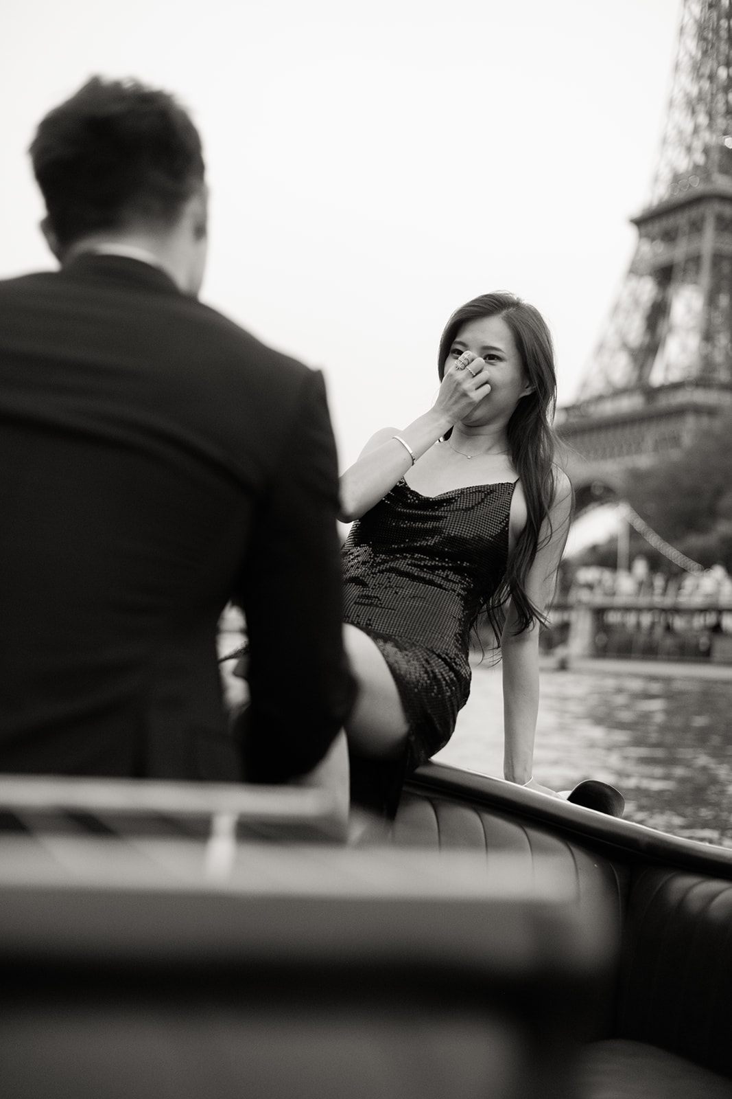 Woman raising a champagne glass during a luxury Paris engagement session at night